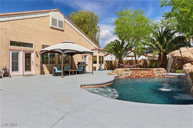 View of swimming pool featuring a grill, a patio area, a fenced in pool, and fence | Image 37