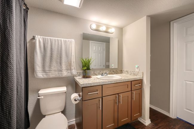 Bathroom featuring baseboards, toilet, vanity, wood finished floors, and a textured ceiling | Image 12
