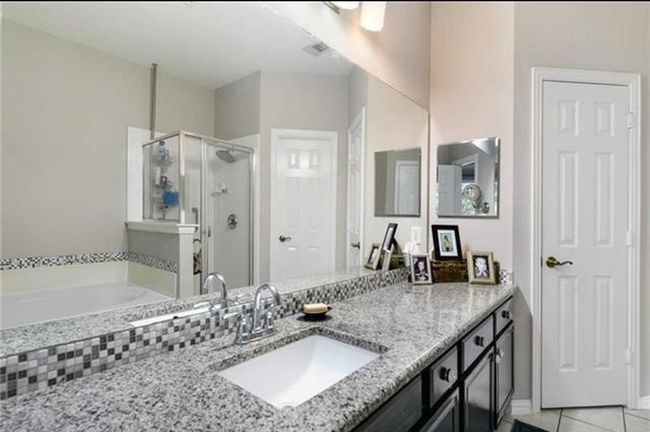 Bathroom featuring tile flooring, vanity with extensive cabinet space, and independent shower and bath | Image 11