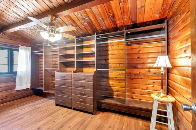 Spacious closet featuring a ceiling fan, light wood-type flooring, and beamed ceiling | Image 21