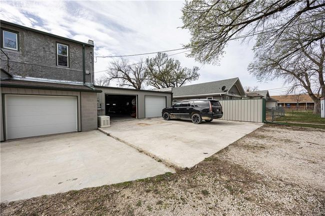 View of home's exterior with a garage, concrete driveway, stucco siding, and fence | Image 60