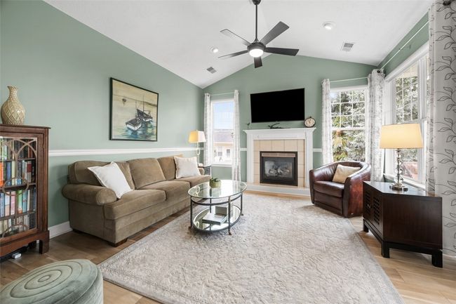 A vaulted ceiling thanks to the second level unit as well as gas fireplace are highlights of the family room. | Image 10