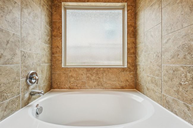 Bathroom featuring a tub to relax in and plenty of natural light | Image 24