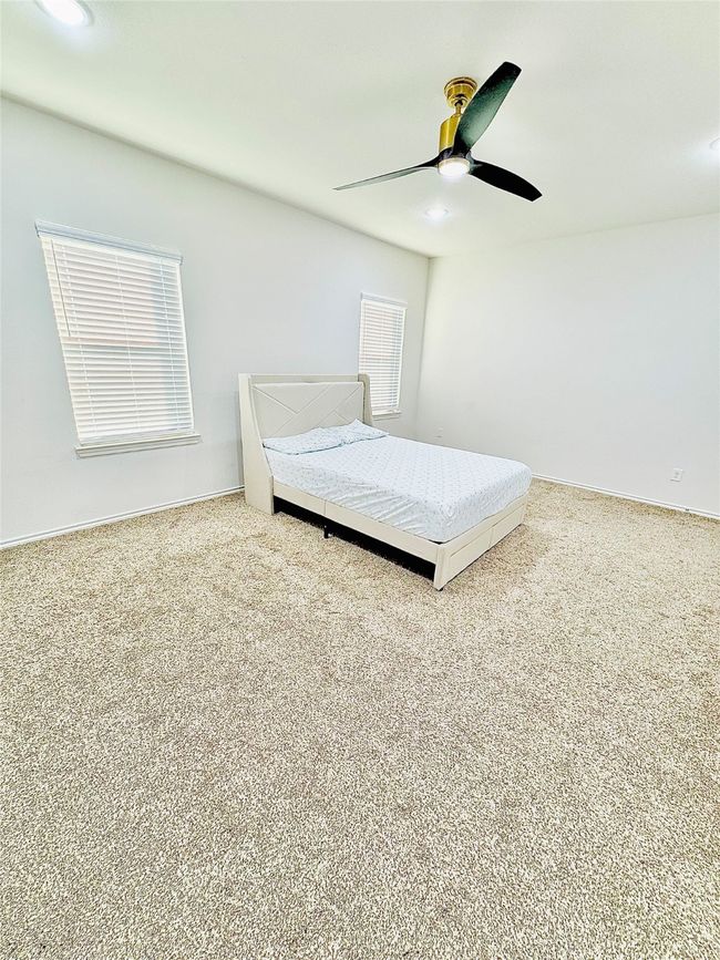 Bedroom with carpet flooring, ceiling fan, and baseboards | Image 26