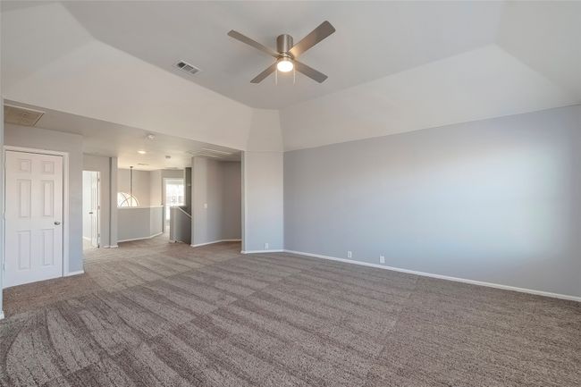 Unfurnished room with baseboards, visible vents, a ceiling fan, lofted ceiling, and carpet floors | Image 29