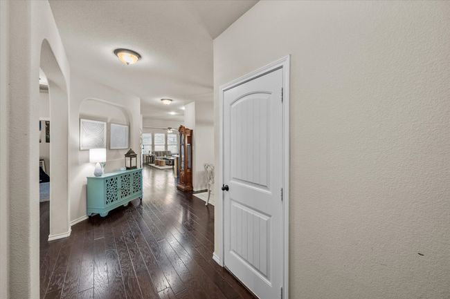 Corridor with arched walkways, hardwood / wood-style flooring, and baseboards | Image 5