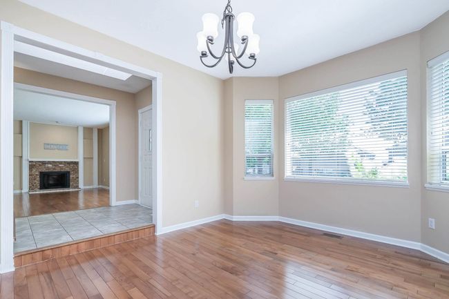 Spare room featuring a wealth of natural light, a chandelier, and hardwood / wood-style floors | Image 6