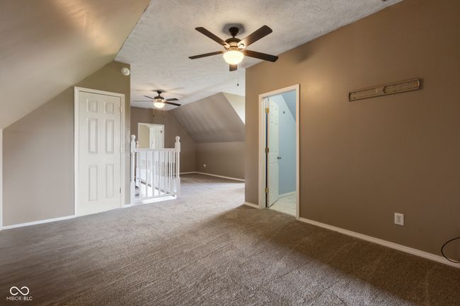 additional living space featuring lofted ceiling, a textured ceiling, a ceiling fan, and carpet floors | Image 22