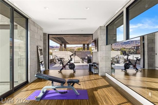Exercise area featuring floor to ceiling windows and wood finished floors | Image 43