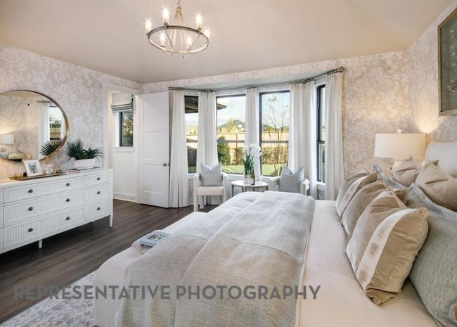 Bedroom with wallpapered walls, dark wood-style flooring, vaulted ceiling, and a chandelier | Image 17