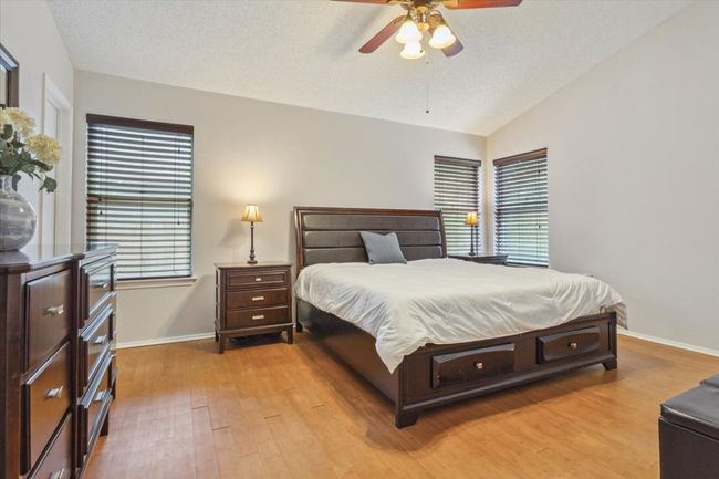Large Primary Bedroom with wood flooring, high ceilings and natural sunlight | Image 16