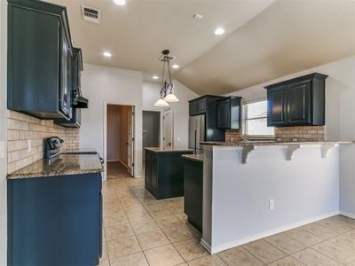 The large kitchen hs been modernized with freshly painted cabinets | Image 3