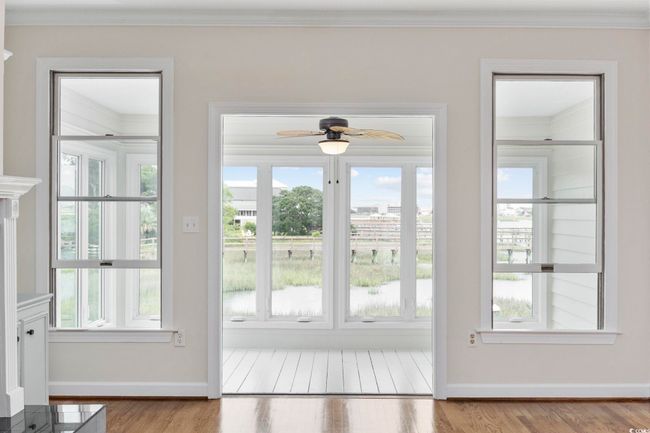 Doorway to outside with crown molding, ceiling fan, wood finished floors, baseboards, and plenty of natural light | Image 15