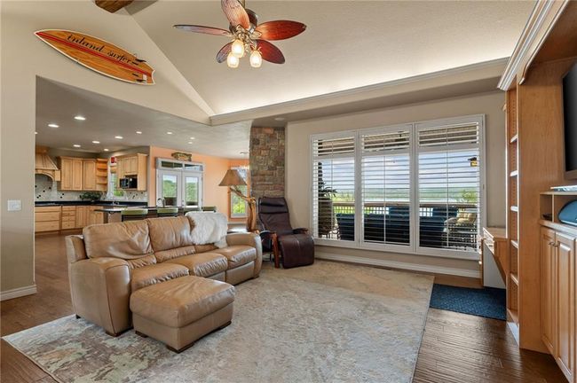 Living area featuring lofted ceiling, ceiling fan, french doors, recessed lighting, and wood finished floors | Image 10