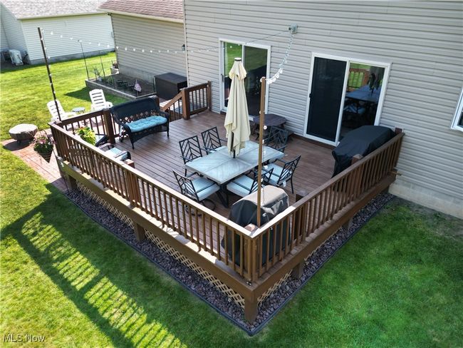 Deck with outdoor dining space and a lawn | Image 9