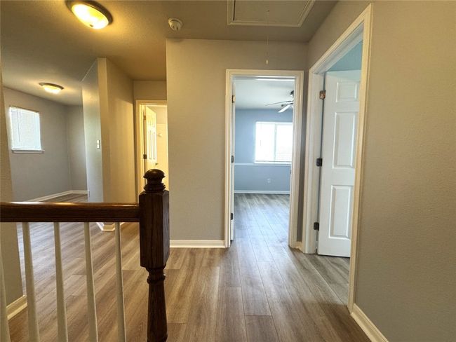 Hallway featuring attic access and wood finished floors | Image 7