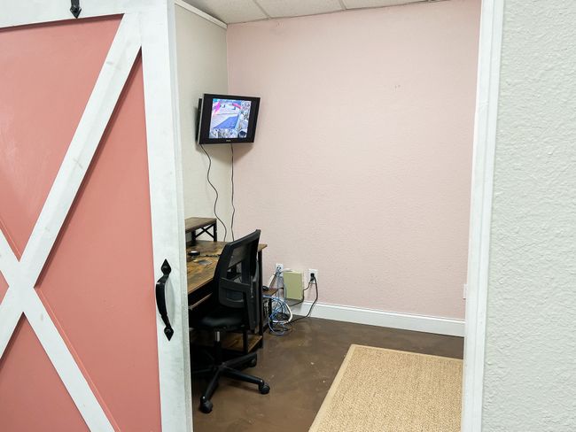 Office area featuring concrete flooring, a textured wall, a drop ceiling, and baseboards | Image 11