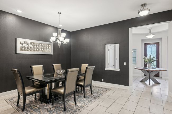Dining room is spacious, featuring a chandelier, custom lightings, and recessed lighting, custom wall paint | Image 10