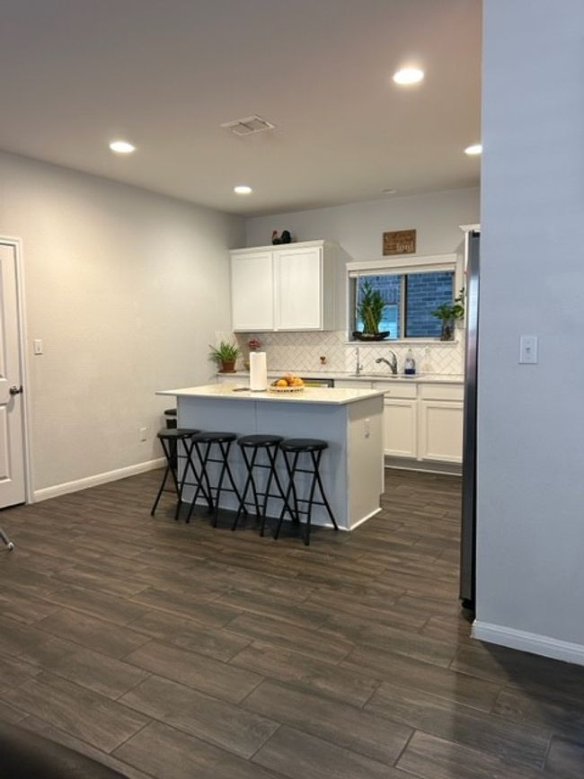 Kitchen with backsplash, dark wood-style flooring, baseboards, recessed lighting, and white cabinetry | Image 12