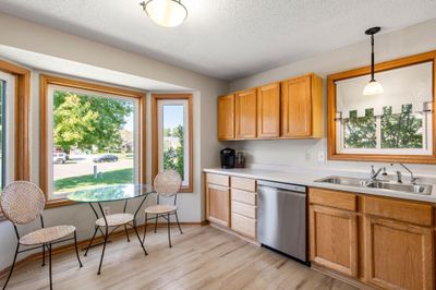 It features abundant cabinetry, stainless steel appliances—including a brand-new dishwasher and microwave—and a cozy breakfast nook framed by a bay window with views of the front yard. | Image 3