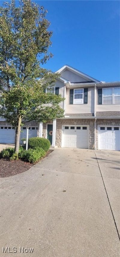 Townhome / multi-family property with a garage | Image 1