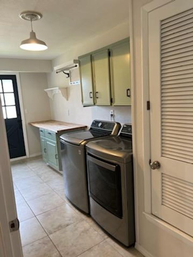 Washroom with cabinet space, light tile patterned floors, and baseboards | Image 6
