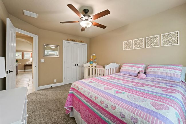 Bedroom with a ceiling fan, a closet, light carpet, baseboards, and visible vents | Image 25