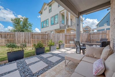 Enjoy a nice-sized backyard featuring a custom covered patio area, perfect for outdoor dining and relaxation. This inviting space offers ample room for activities and gatherings, making it an ideal spot for entertaining and enjoying the outdoors. | Image 1