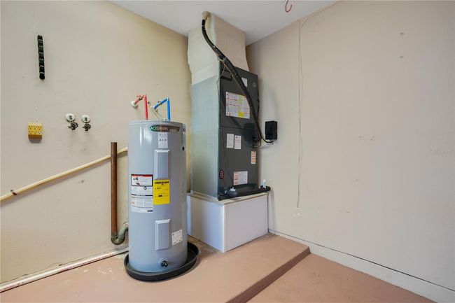 Brand new hot water heater and AC unit in garage with insulated garage door. | Image 30