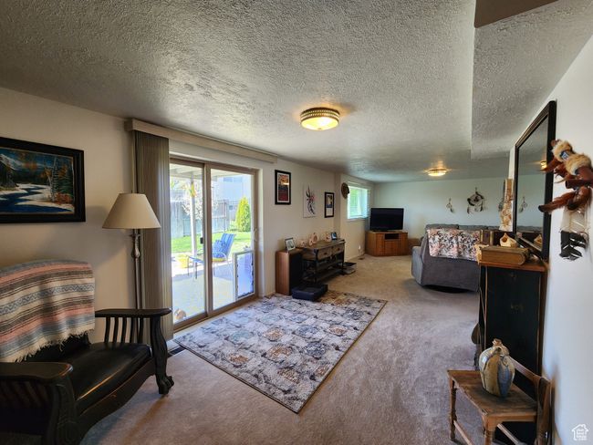 Carpeted living room featuring a textured ceiling | Image 29