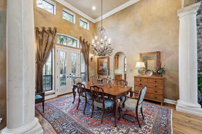 Sunlight pours in through the French Doors, transoms and windows. Three custom-designed, insulated, leaded transoms float above at the 16' ceiling in the expansive formal dining room. This room will accommodate even the largest of dinner parties and holiday meals with lovely views of the courtyard. | Image 7