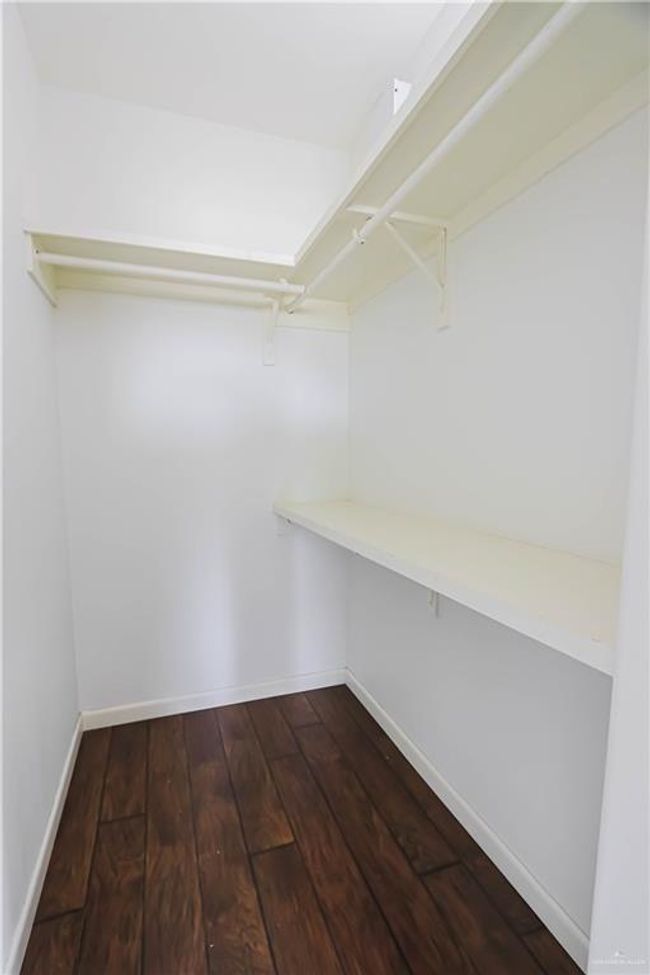 Walk in closet featuring dark wood finished floors | Image 18