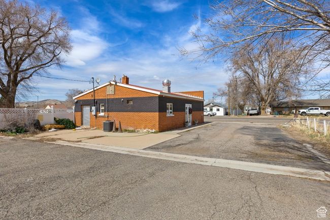 Exterior space featuring central air condition unit, a chimney, fence, and brick siding | Image 17