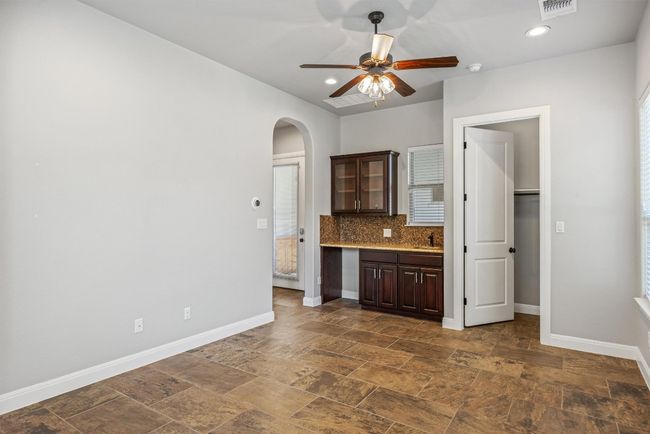 Attached casita features kitchenette, with sink, space for small refrigerator, recessed lighting, tasteful backsplash, arched walkways, and ceiling fan | Image 12