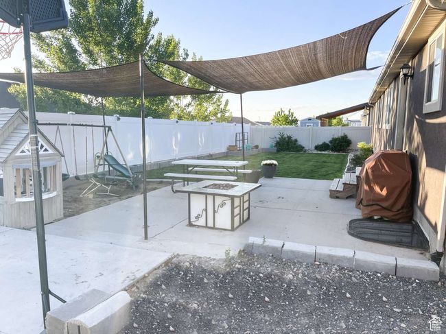 View of patio featuring an outdoor fire pit and area for grilling | Image 24