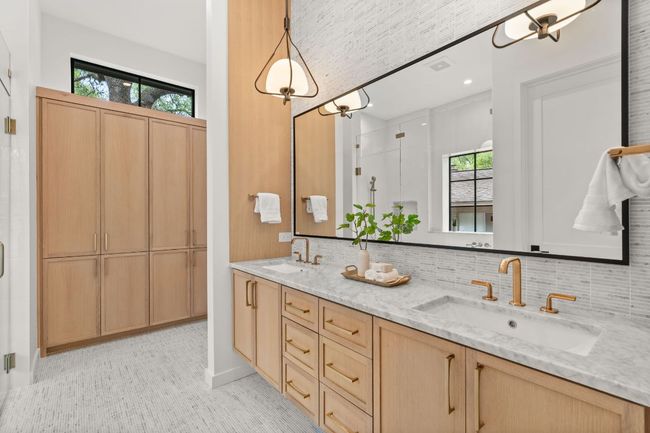 The primary bathroom features custom cabinetry allowing maximum storage. | Image 17