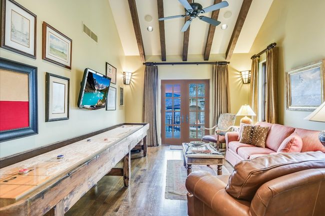 Living area with visible vents, beamed ceiling, ceiling fan, wood finished floors, and french doors | Image 34