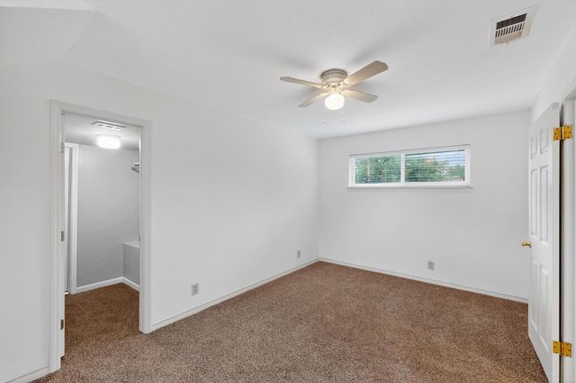Unfurnished bedroom featuring carpet flooring, a spacious closet, a closet, and ceiling fan | Image 24