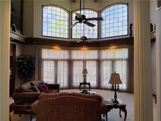 Living room with a ceiling fan and a towering ceiling | Image 19