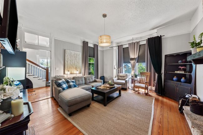 Living room with plenty of natural light, stairs, wood-type flooring, and a textured ceiling | Image 10