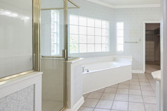 Full bath featuring ornamental molding, tile patterned floors, a shower stall, and a garden tub | Image 13