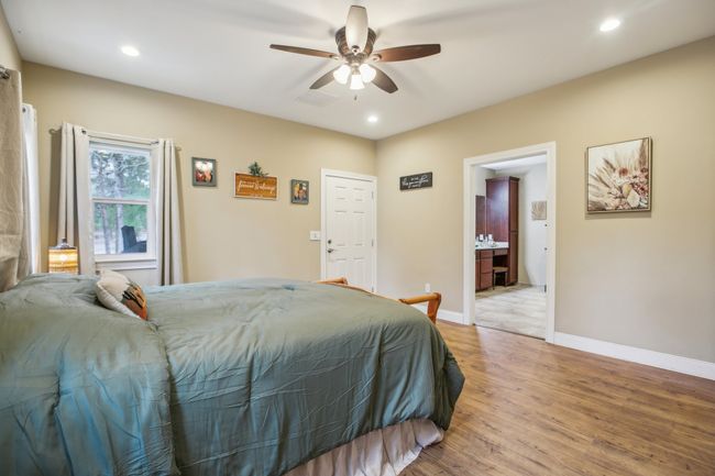 Bedroom featuring hardwood / wood-style flooring, ceiling fan, and ensuite bathroom | Image 24