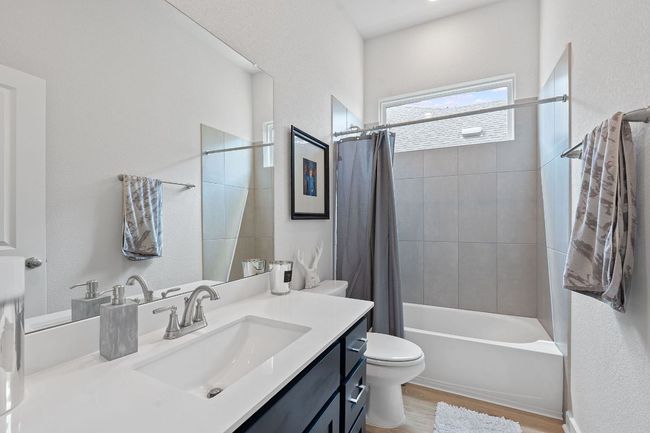 Bathroom with wood finished floors, toilet, vanity, and shower / bath combination with curtain | Image 22