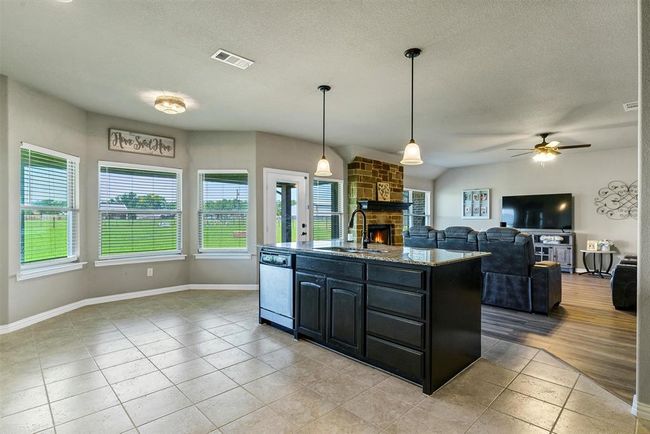 Kitchen featuring a healthy amount of sunlight, sink, white dishwasher, and a fireplace | Image 13