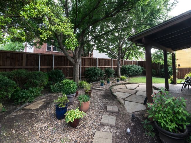 WOW! Just gorgeous board-on-board fenced backyard with its covered cedar patio, manicured landscaping, and flagstone patio extension. Mature trees supply lots of shade for those summertime afternoons. | Image 34