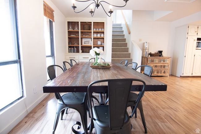 Dining room with a chandelier, light wood-style flooring, and stairs | Image 6