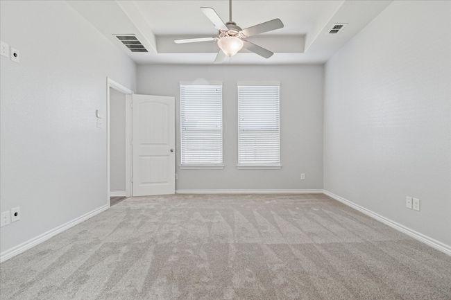 Primary bedroom featuring a raised ceiling, and ceiling fan | Image 17