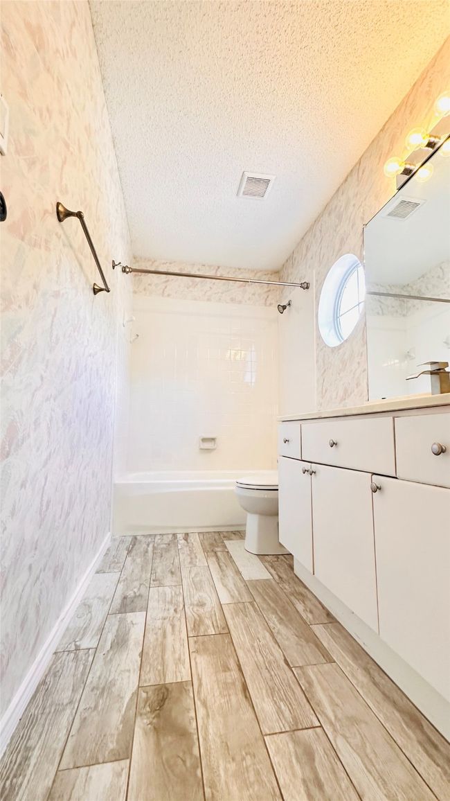 Full bathroom featuring shower combination, a textured ceiling, vanity | Image 9