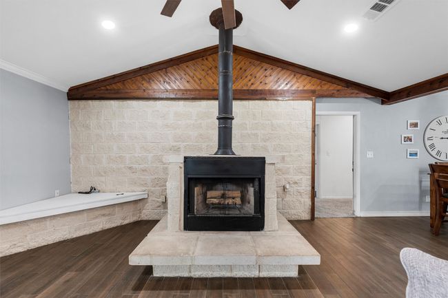 Detailed view of wood finished floors, beam ceiling, crown molding, and a ceiling fan | Image 9