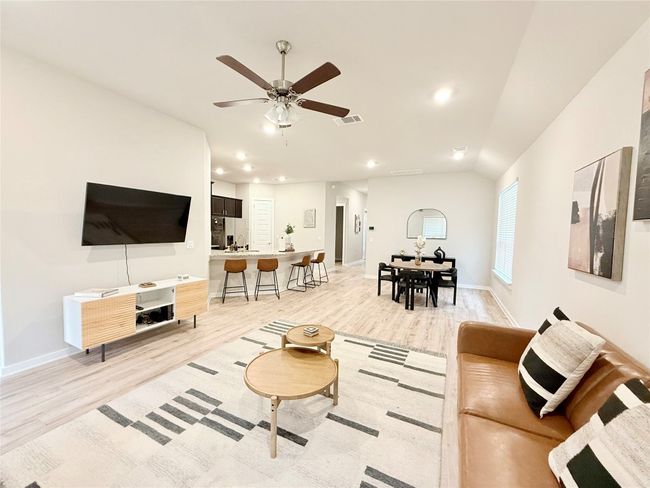 Living area featuring visible vents, baseboards, ceiling fan, light wood-style floors, and recessed lighting | Image 14